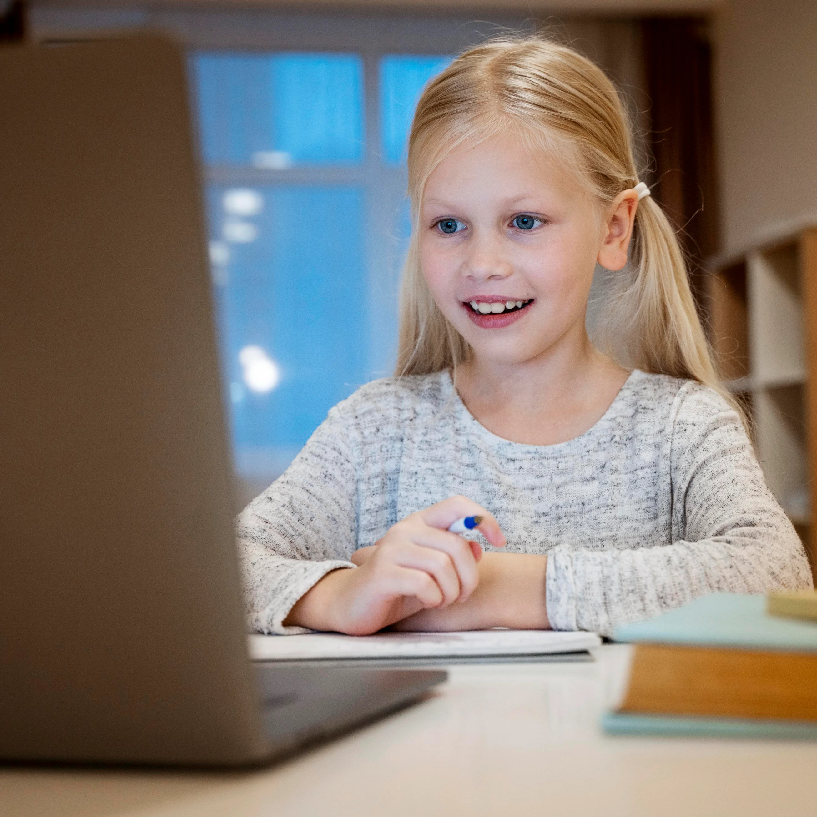 Kid attending an online tutoring session on a laptop